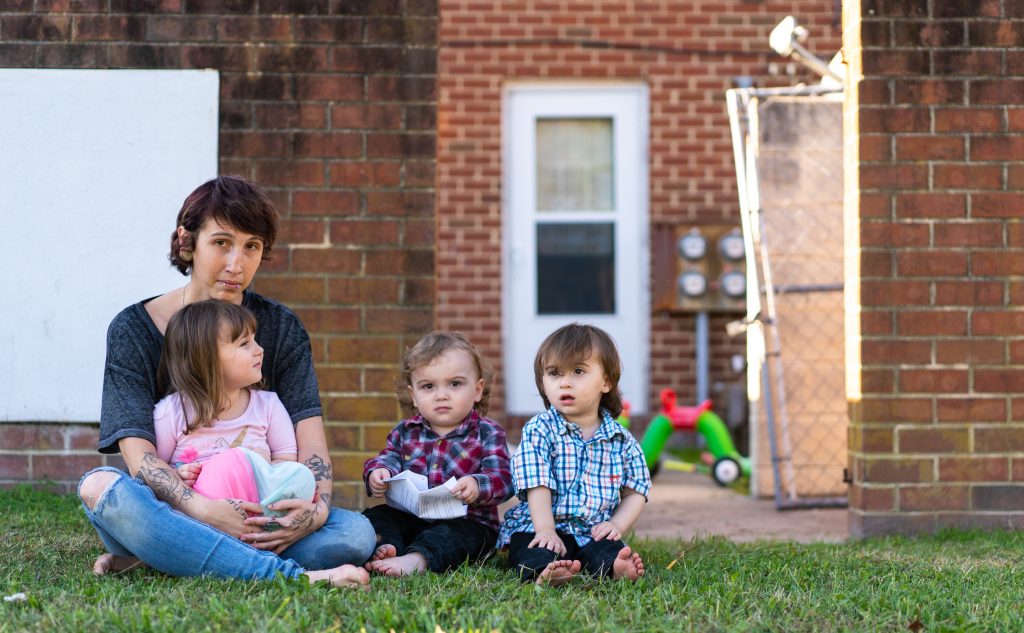 Kandise Norris, shown here with her three children in a Nov. 7 photo outside their home in Somerset County, Maryland, says she has been rebuilding her life since getting treatment for drug addiction in April 2019. The Housing Authority of Crisfield, which owns her house, has filed three eviction cases against the 30-year-old since September. (Nick McMillan/Howard Center)